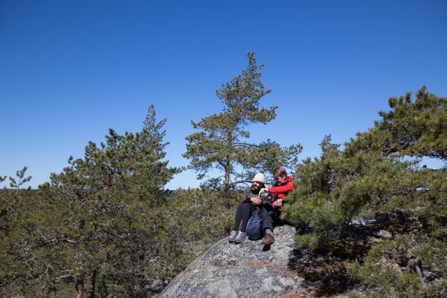 Couple sitting close to Borgberg high up on a cliff and drinking coffee